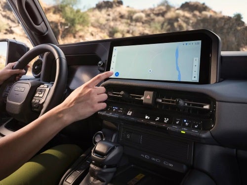 2025 Toyota Land Cruiser view of person using touchscreen for navigation